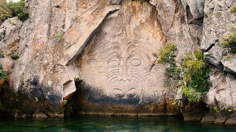 Maori symbol stone carving at a rock wall
